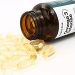 Ein geöffnetes braunes Glas Omega 3 Intense liegt seitlich, während zahlreiche goldene Softgel-Kapseln herausrollen. Die Szene zeigt die glänzende Textur und hochwertige Reinheit der Omega 3 Fischöl Kapseln vor hellem Hintergrund.